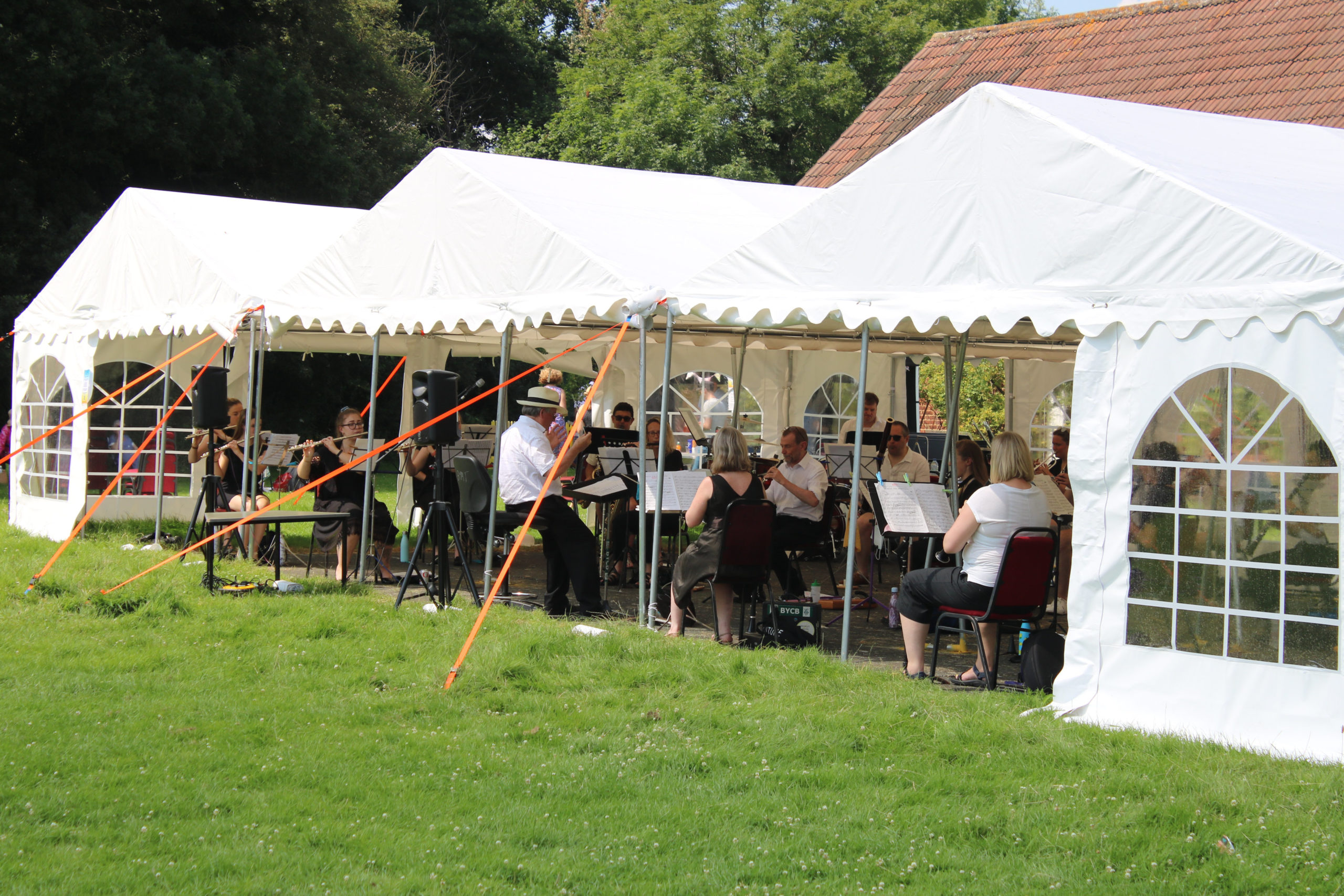 XBY performing outside underneath a marquee